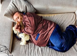 fat man with a soft looking beard sleeping in silky pyjamas