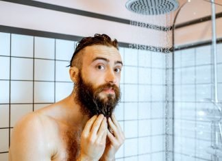 man cleaning beard in the shower